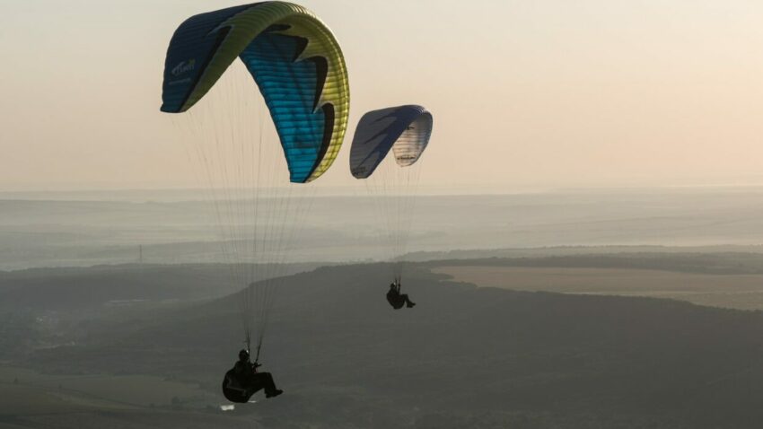 time-lapse photo of two people parachuting during daytime