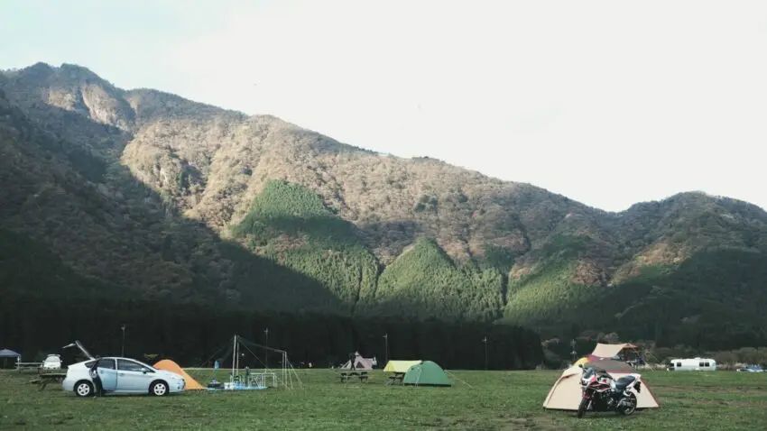 assorted-color dome tents near mountains under white clouds during daytime